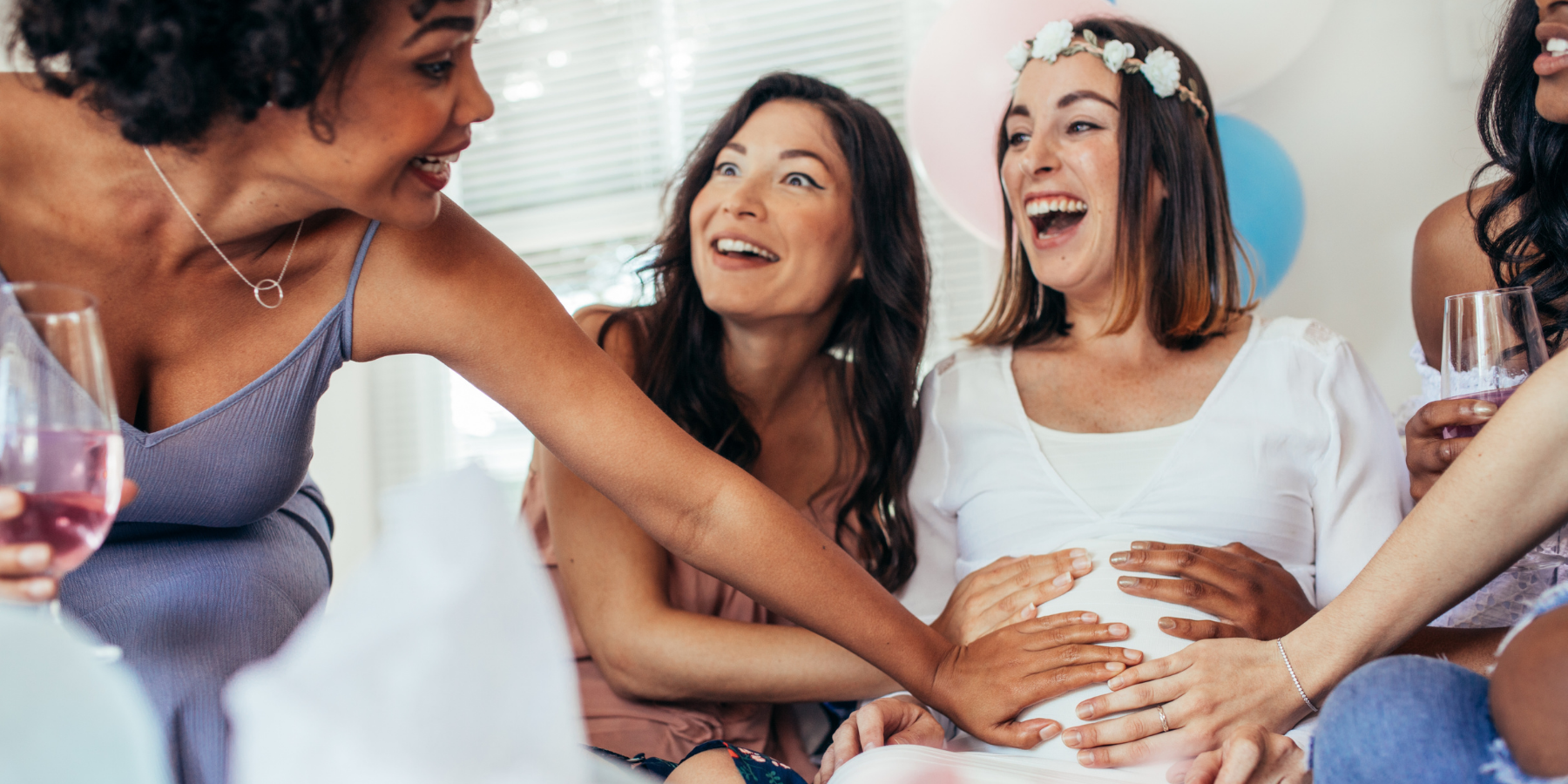 Friends with their hands on a pregnant woman's stomach